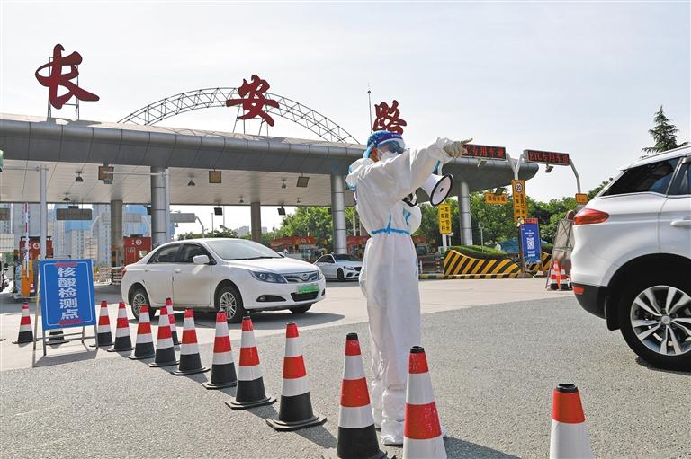 图为5月24日,在西安长安路东口收费站,交警引导有外地行程的车辆进入
