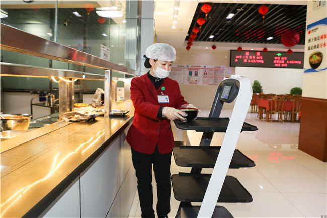 武汉经开外校今秋开学试点送餐机器人，学生可在餐桌上点餐