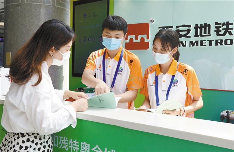 8月27日,西安地铁十四运会志愿者热情为乘客服务.