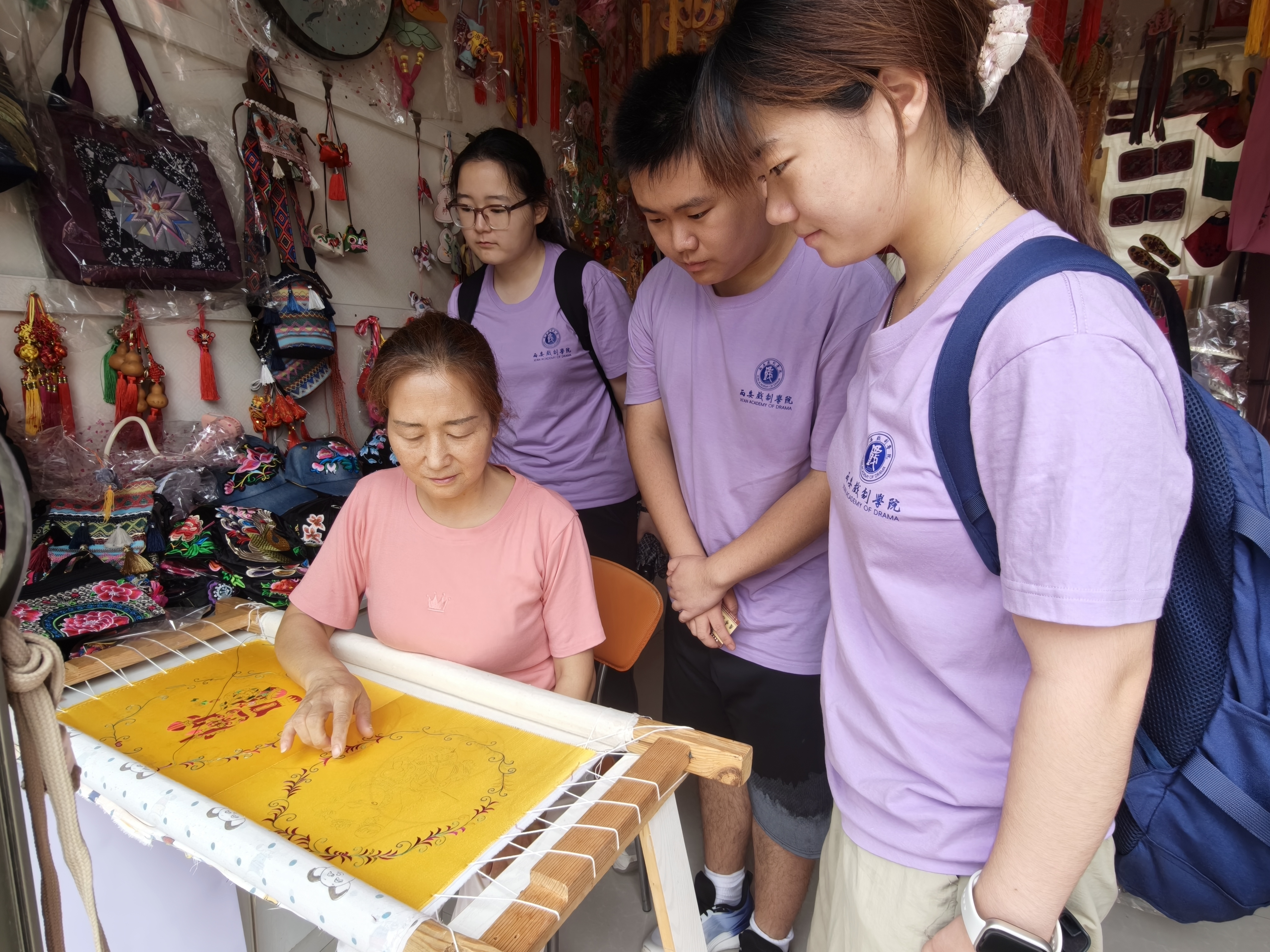 图为国家高级工艺美术师、西秦刺绣市级代表性传承人姚怀侠向实践团成员讲解刺绣技法