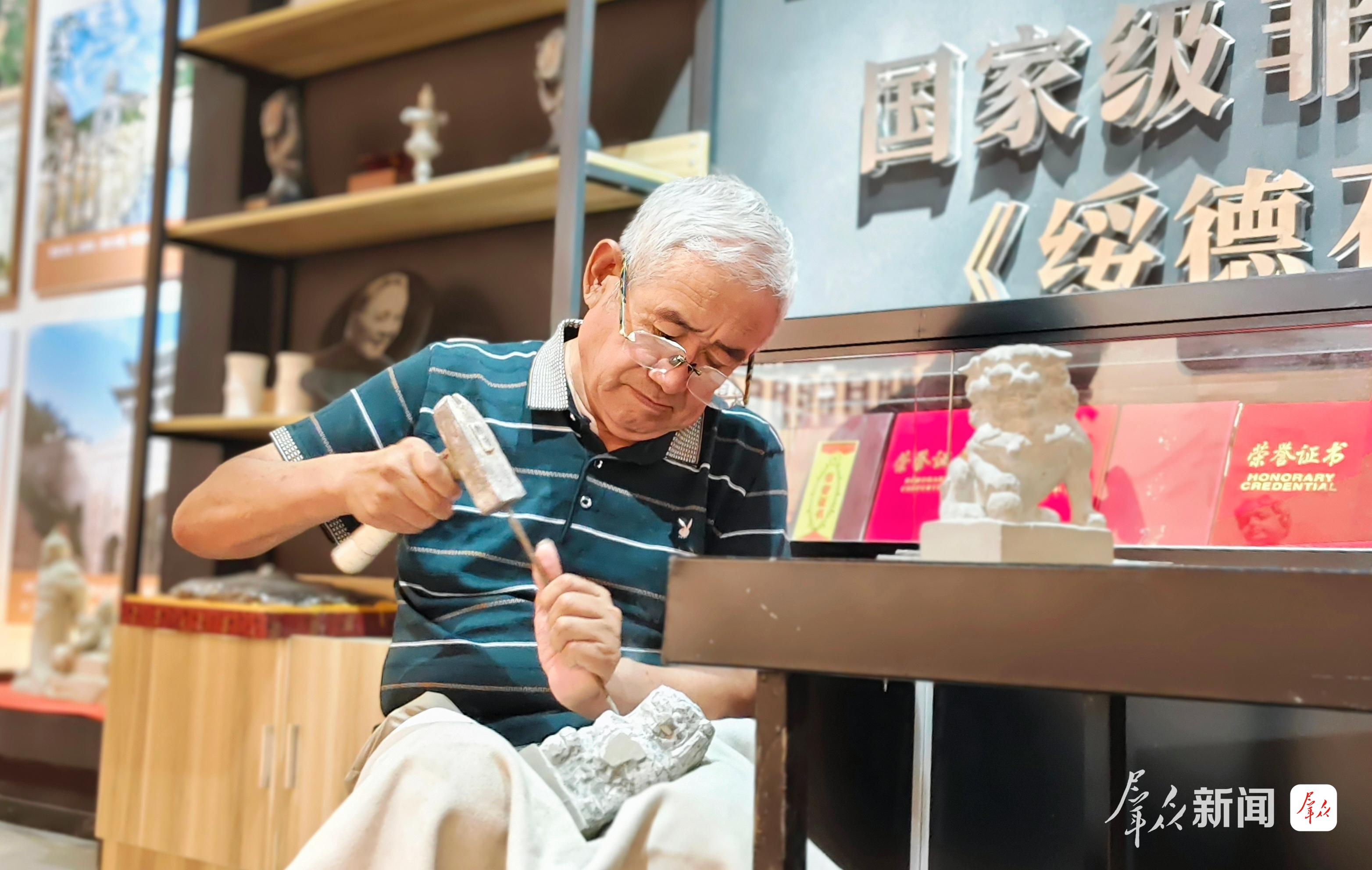 鲍武文正在雕刻石狮。