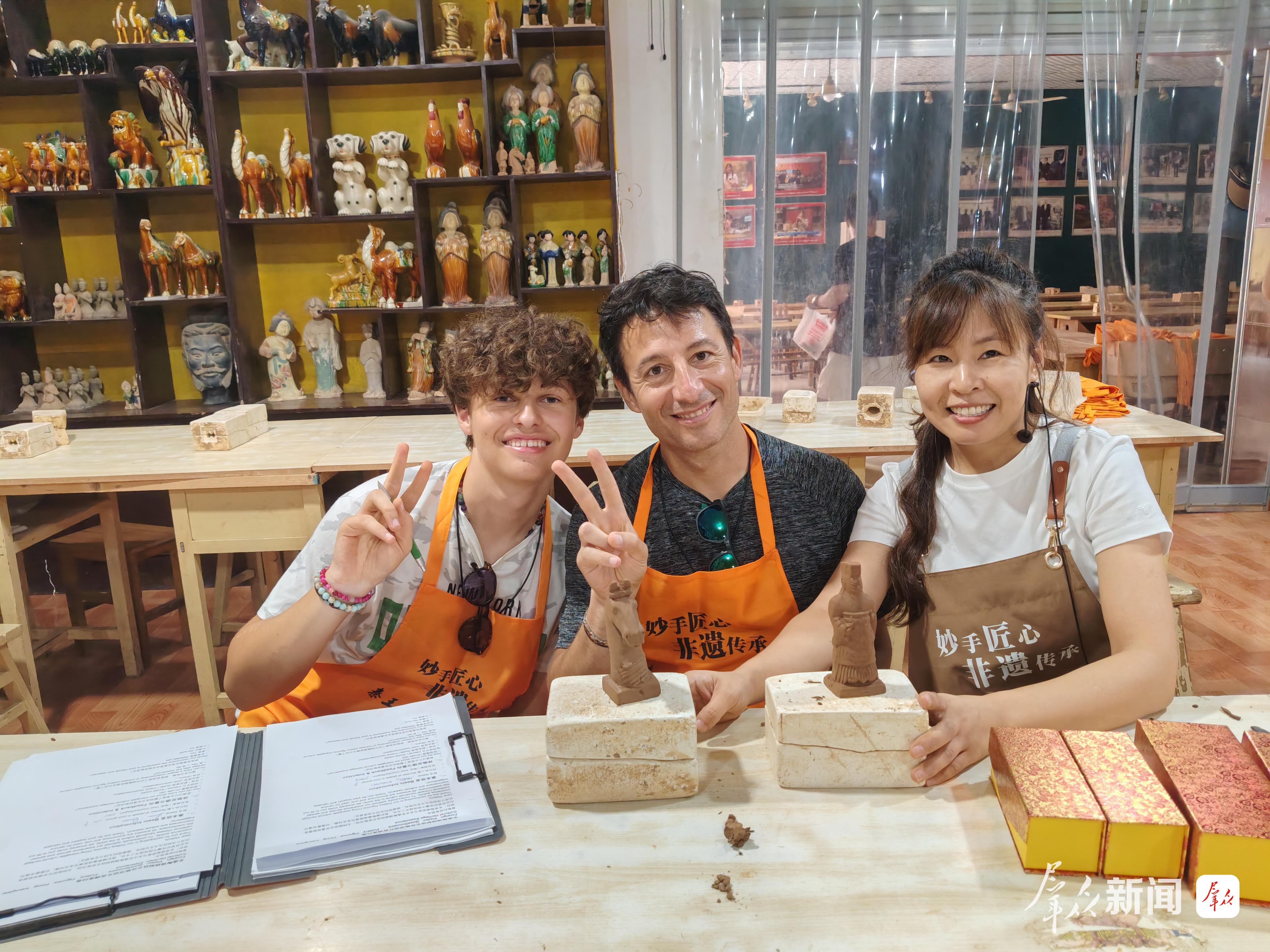 图为意大利游客卢卡(左一)在体验陶俑制作。通讯员 王三合摄