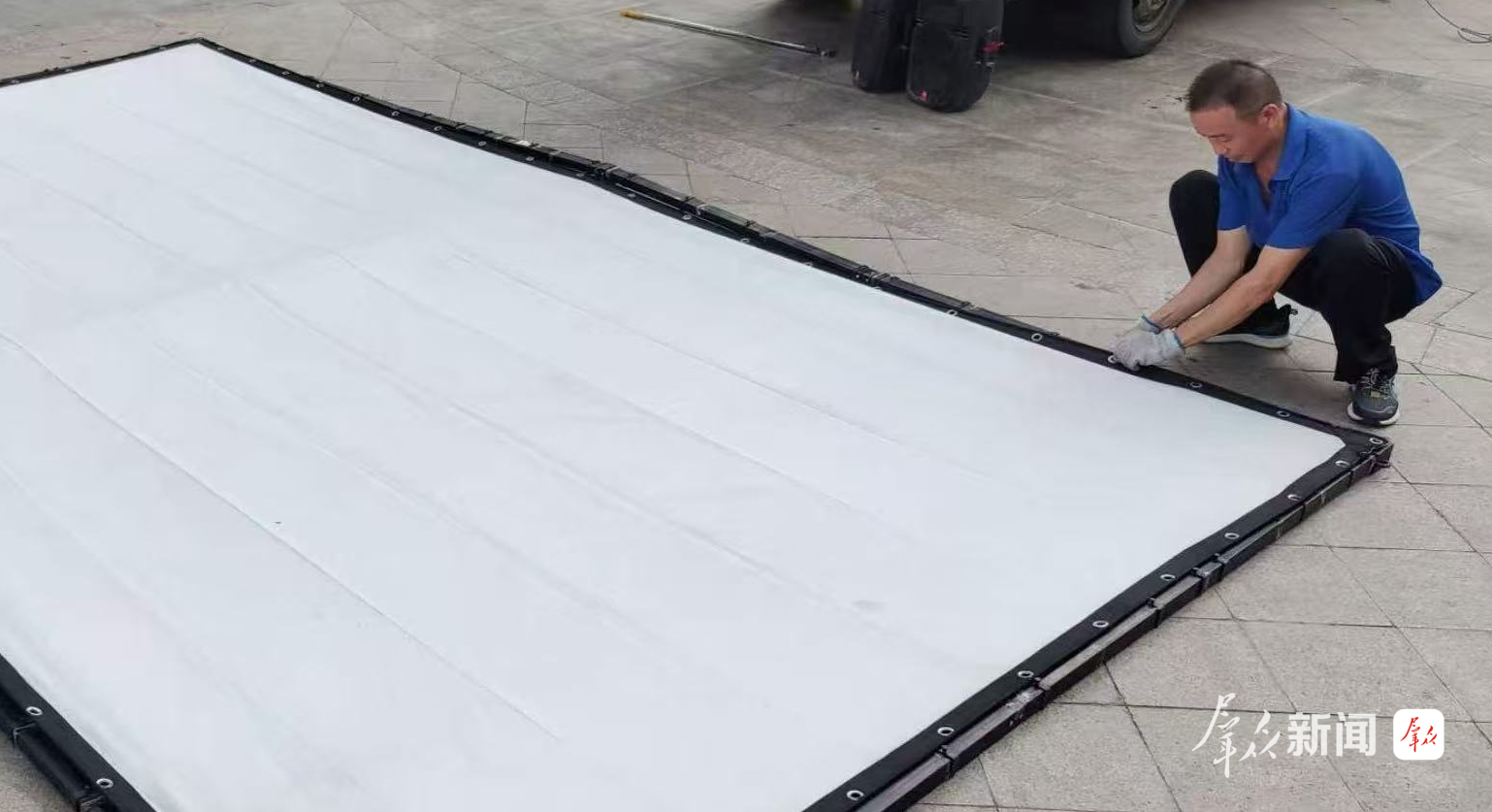放映员王宗武在搭设放映幕布。