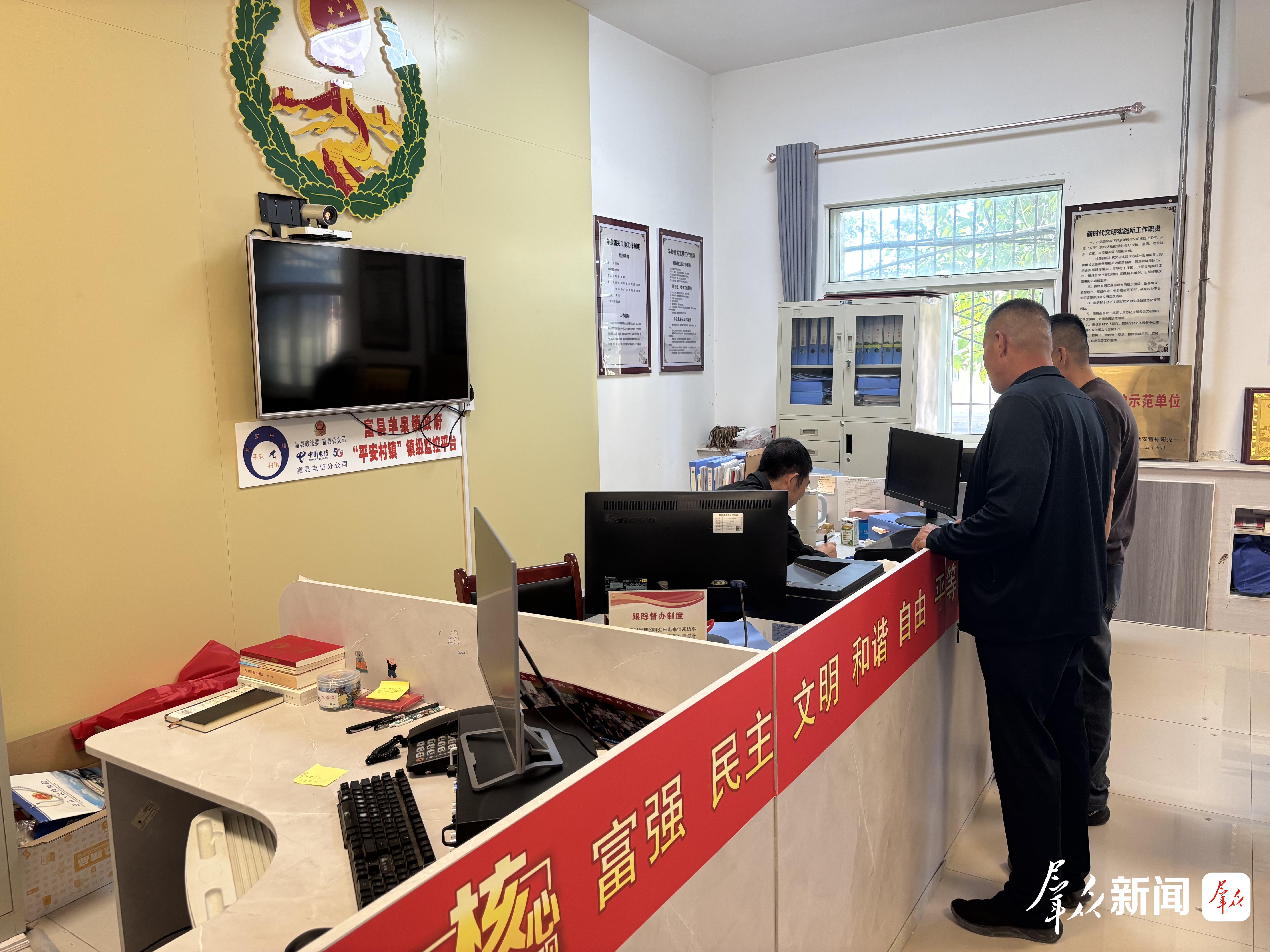羊泉镇村民在镇综治中心向工作人员了解矮化密植园建园政策。